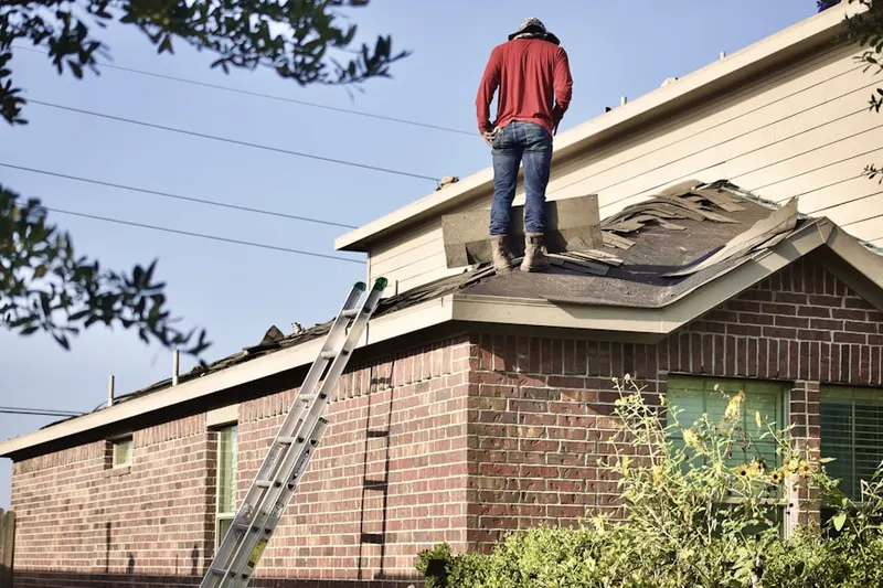 Professional roofer working on a residential roof in Divine Redeemer